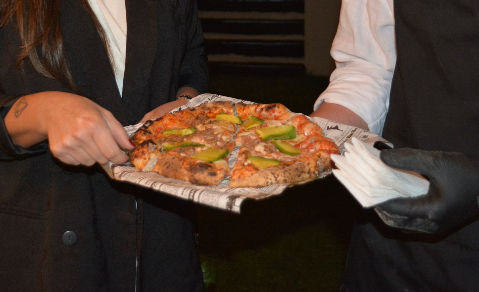Garzón sirviendo pizza napolitana en evento